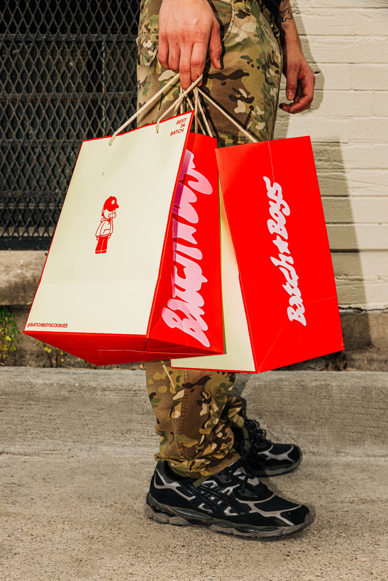 Red and cream Batch Boys shopping bags carried down a Toronto street